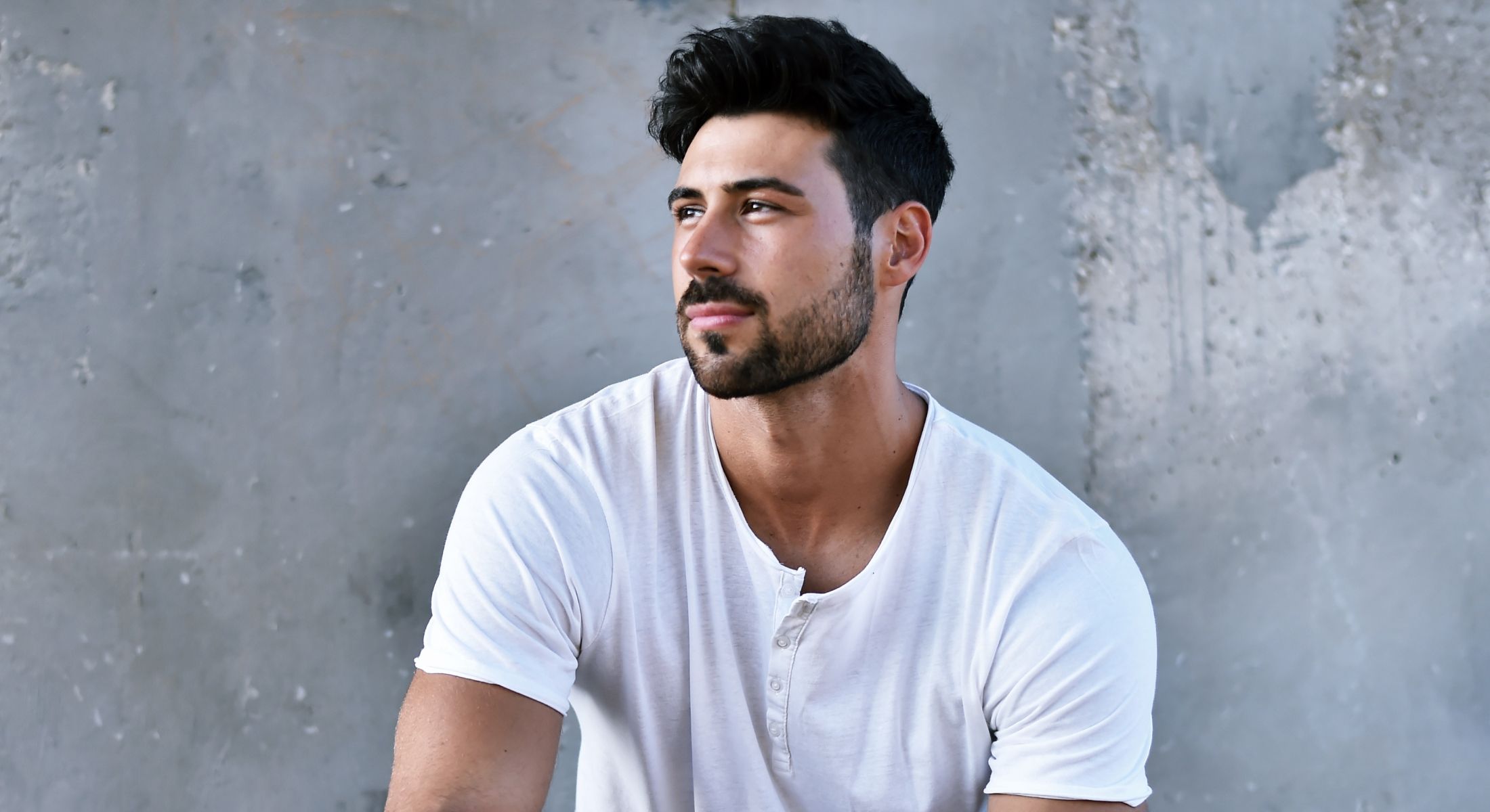 Man with stylish hair in casual white shirt.